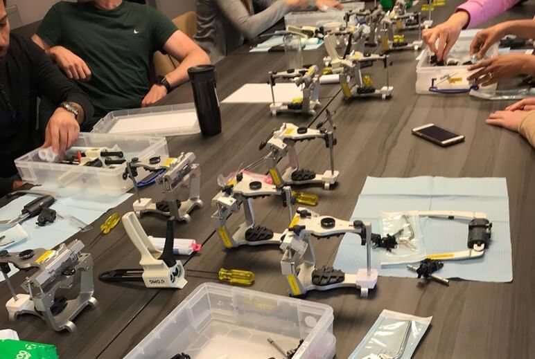 Table with different occlusion products and tools with people interacting with them.